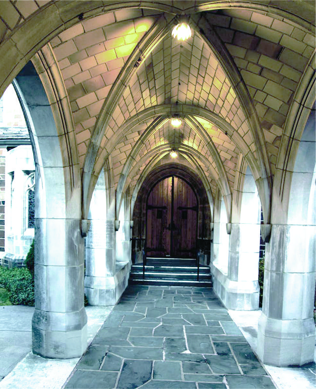 Finished ribbed-vault stone arcade leading to a timber door.